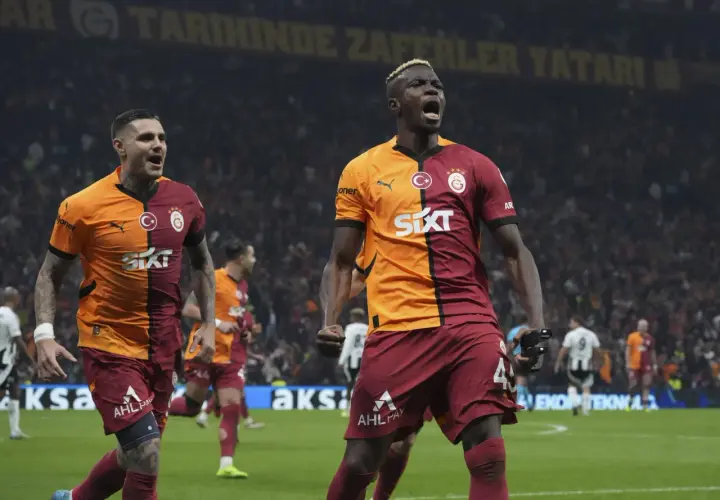 Dwóch zawodników Galatasaray świętuje zwycięstwo na boisku.