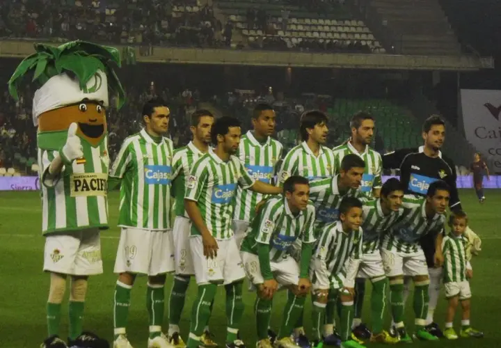 Real Betis – zawodnicy w zielono-białych strojach pozują do zdjęcia z maskotką.