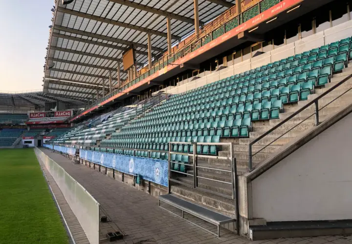 Puste trybuny stadionu A. Le Coq Arena czekają na kibiców. Zielone krzesełka tworzą morze nadziei na emocjonujące mecze.