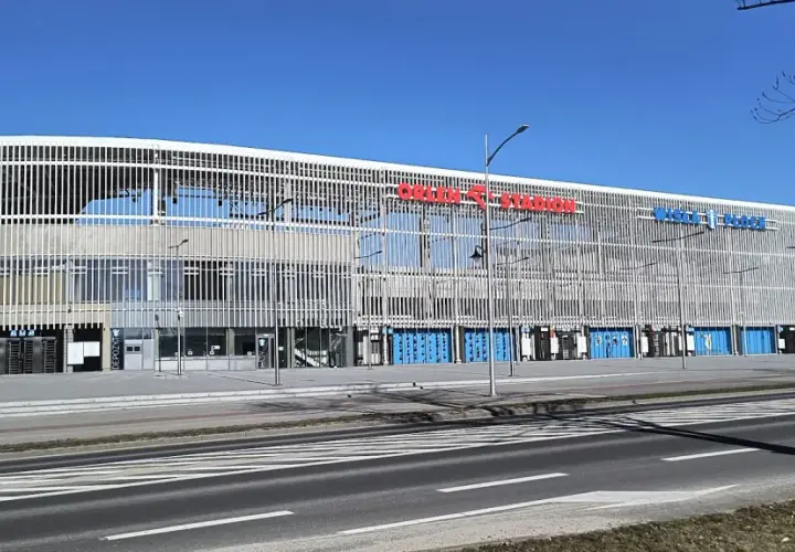 Nowoczesny stadion im. Kazimierza Górskiego w Płocku, z charakterystyczną, ażurową fasadą i niebieskimi bramami.