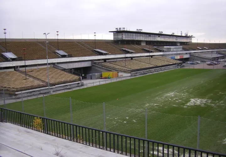 Pusta trybuna stadionu, największy stadion w Czechach, z zieloną murawą i ogrodzeniem.