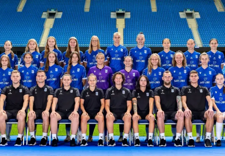 Drużyna piłkarska Lech Poznań UAM w komplecie, gotowa do gry na stadionie.