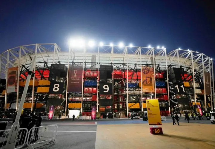 Nocny widok na **stadion z kontenerów Katar** z numerowanymi sekcjami i banerami Mistrzostw Świata FIFA 2022.