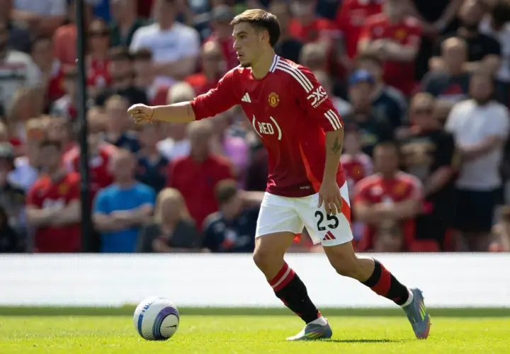 Manuel Ugarte w czerwonej koszulce Manchesteru United z numerem 25, biegnie po boisku, skupiony na grze.