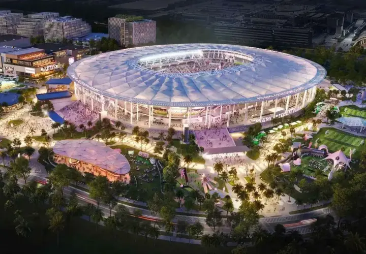 Nowoczesny **Inter Miami stadium** z rozsuwanym dachem, otoczony parkiem z boiskami i atrakcjami, nocą.