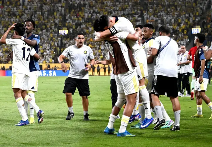 Piłkarze świętują zwycięstwo, przytulając się na boisku. W tle tłum kibiców, którzy przyszli zobaczyć, kiedy gra Ronaldo.