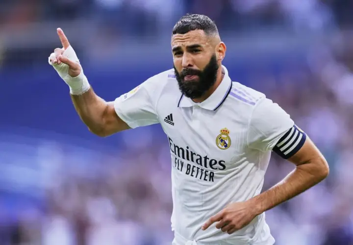 Piłkarz z numerem 8, Karim Benzema, świętuje bramkę. Ma zabandażowaną dłoń i opaskę kapitana na ramieniu.