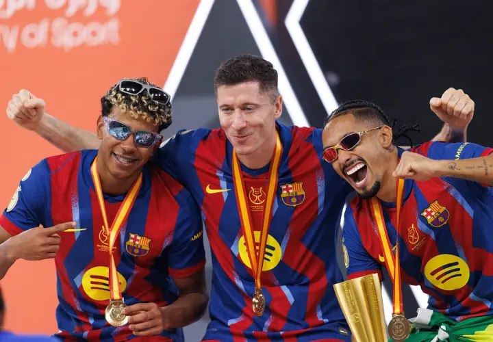 Trzej zawodnicy FC Barcelony w okularach przeciwsłonecznych świętują zdobycie Superpucharu Hiszpanii.