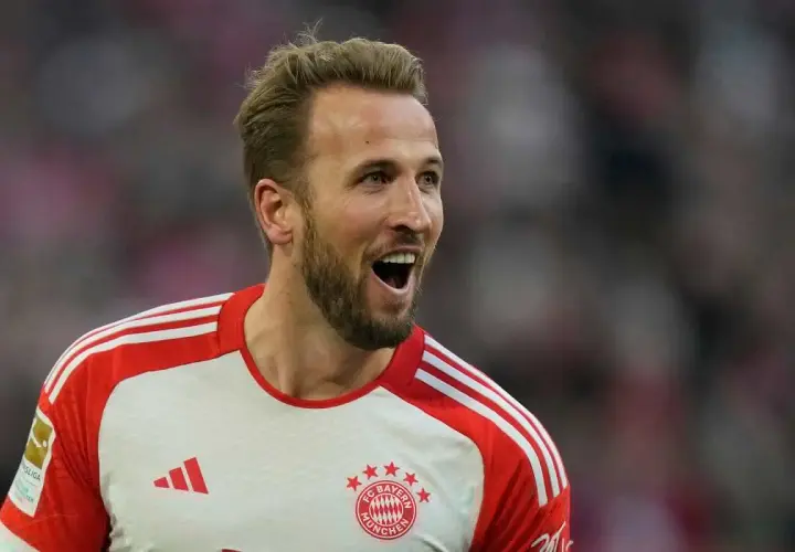 Harry Kane w koszulce Bayernu Monachium, z otwartymi ustami, radośnie reaguje na wydarzenia na boisku.