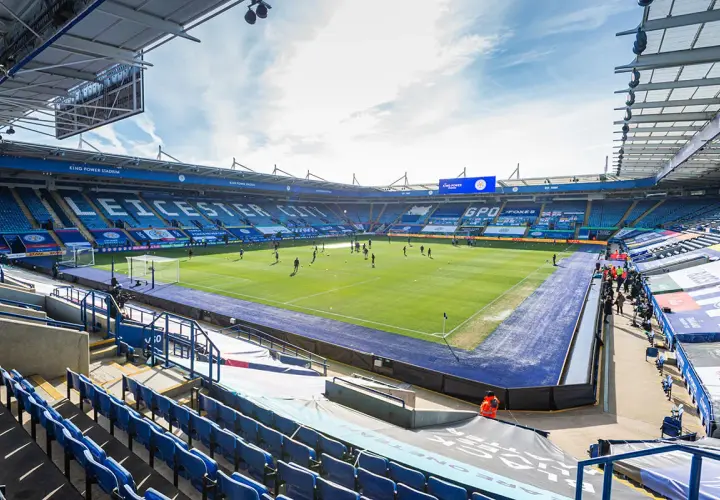 Piłkarze trenują na murawie King Power Stadium. Puste trybuny w niebieskich barwach czekają na kibiców.