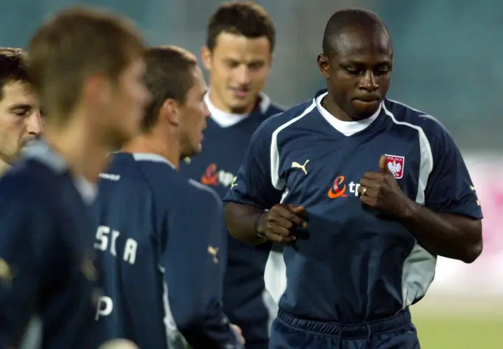 Emmanuel Olisadebe w koszulce reprezentacji Polski. Daty dołączenia do kadry to ważny moment w jego karierze.