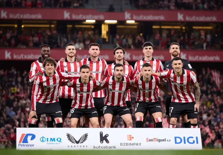 Athletic Bilbao – zawodnicy w czerwono-białych pasach stoją razem przed kibicami.