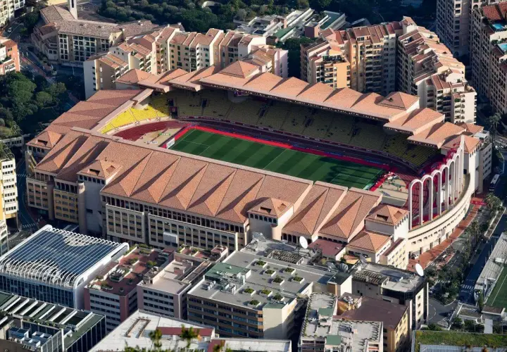 Stadion AS Monaco z lotu ptaka, otoczony budynkami mieszkalnymi i zielenią.