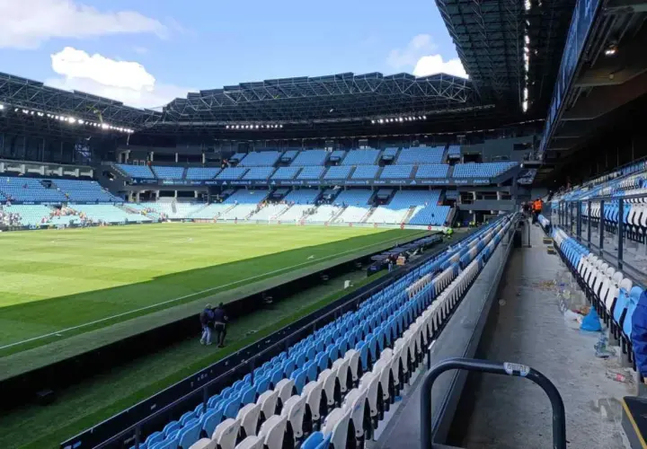 Puste trybuny stadionu Celta Vigo czekają na kibiców. Zielona murawa lśni w słońcu.
