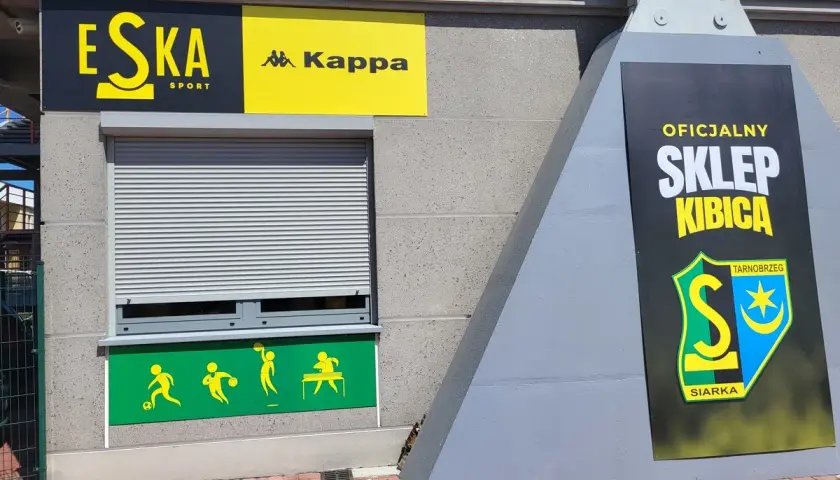 Oficjalny sklep kibica Siarki Tarnobrzeg na stadionie. Logo klubu i napisy "Eska Sport", "Kappa".