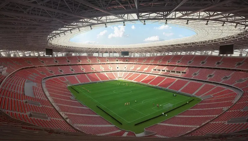 Nowy stadion w Budapeszcie z zieloną murawą i czerwonymi trybunami. Piłkarze trenują przed meczem.