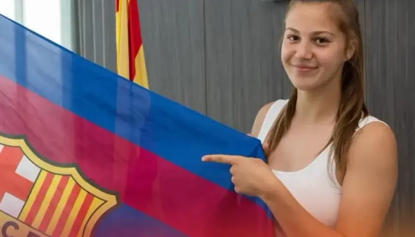 Uśmiechnięta Emilia Szymczak trzyma flagę FC Barcelony.