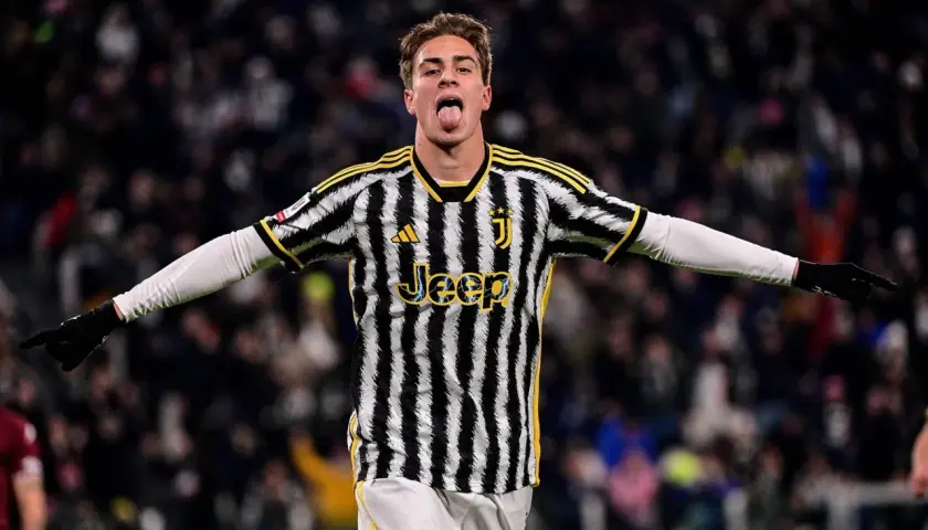 Kenan Yıldız w koszulce Juventusu z językiem na wierzchu, radośnie świętuje bramkę.