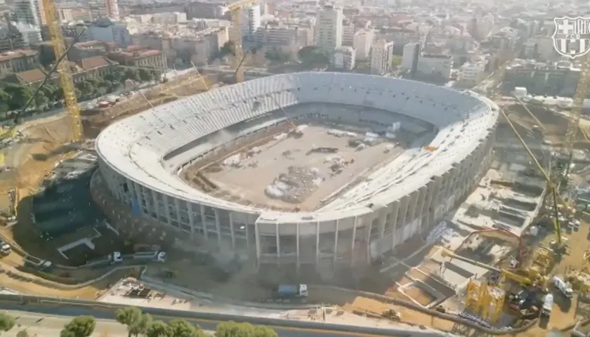 Widok z lotu ptaka na stadion barcelony nowy w budowie. Widać dźwigi i robotników pracujących nad konstrukcją.