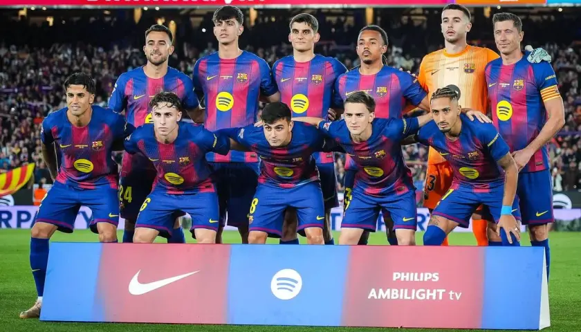 Drużyna FC Barcelona, w tym zawodnicy jak Lewandowski, Pedri i Gavi, pozuje do zdjęcia przed meczem.