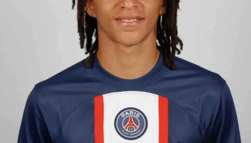 Młody piłkarz Ethan Mbappé w koszulce PSG. Jego wiek to 16 lat.