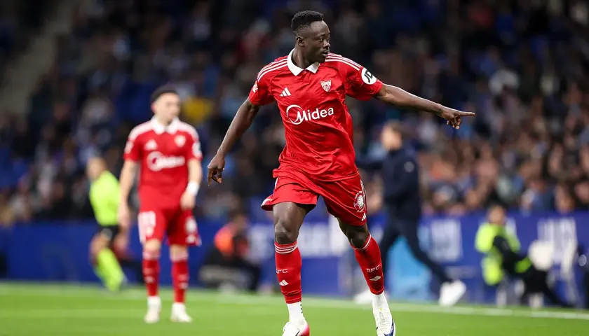 Piłkarz Sevilli w czerwonej koszulce wskazuje palcem, analizując statystyki meczu Getafe CF – Sevilla FC.