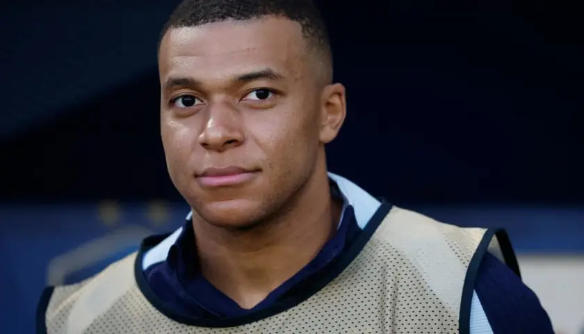 Kylian Mbappé, młody piłkarz z Francji, w kamizelce treningowej. Tak się pisze Mbappé.