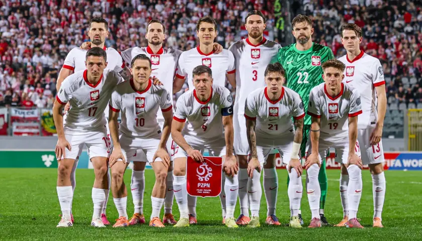 Reprezentacja Polski w piłce nożnej mężczyzn przed meczem z Maltą. Drużyna w białych strojach, z orłem na piersi, gotowa do gry.