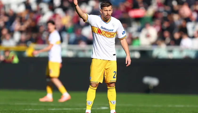Piłkarz w białej koszulce i żółtych spodenkach z numerem 2, na boisku podczas meczu Lecce – Udinese.