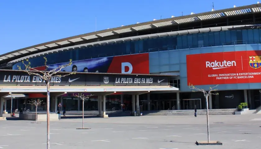 Stadion, gdzie gra Barcelona, z banerem Rakuten i herbem FCB.
