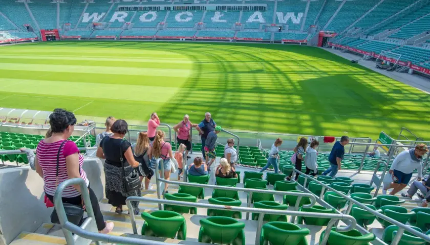 Grupa turystów zwiedza pusty stadion Śląsk Wrocław.