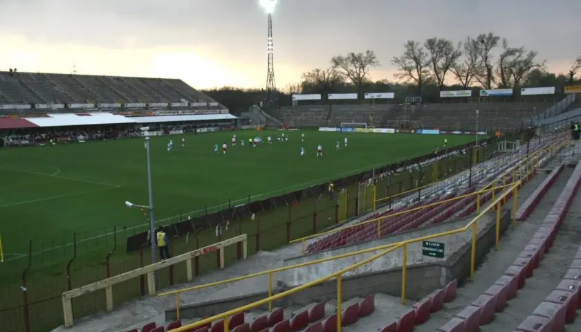 Stary stadion ŁKS, z murawą i trybunami, gdzie trwa mecz.