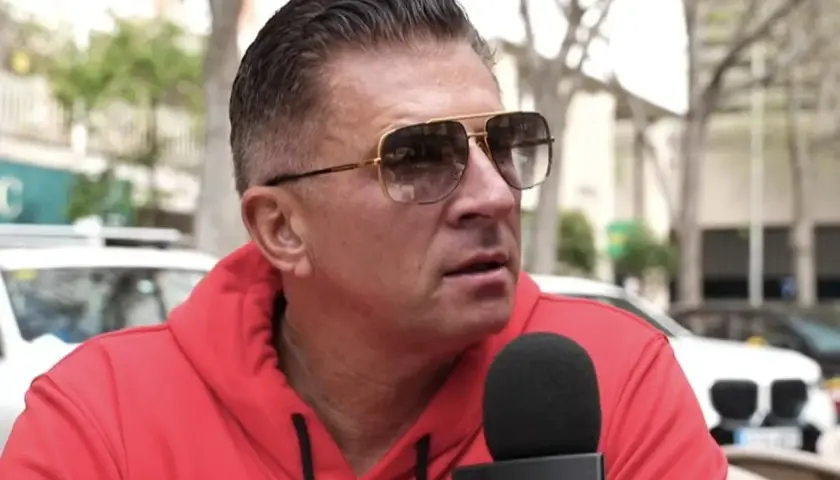 Mateusz Borek w czerwonej bluzie i okularach przeciwsłonecznych udziela wywiadu dla Kanału Sportowego, być może o Real Madryt.