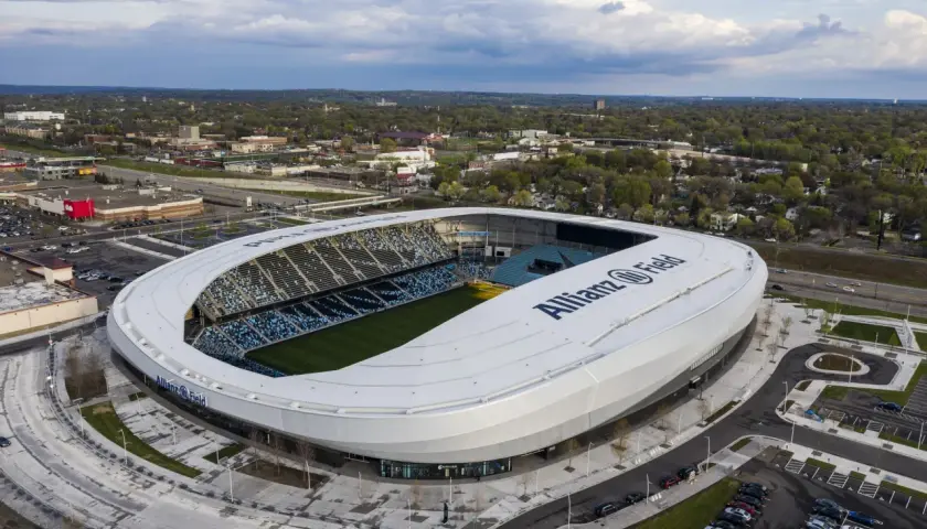 Widok z lotu ptaka na Allianz Field, nowoczesny stadion piłkarski, otoczony zielenią i parkingami.
