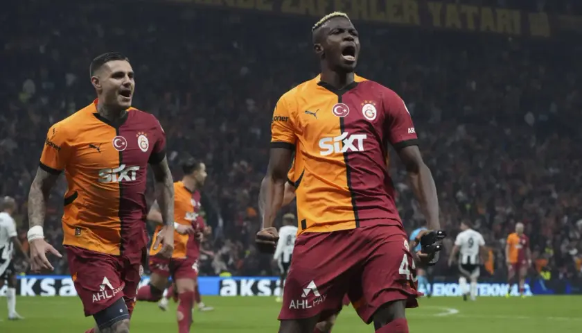 Dwóch zawodników Galatasaray świętuje zwycięstwo na boisku.