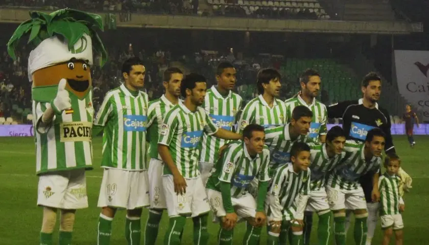 Real Betis – zawodnicy w zielono-białych strojach pozują do zdjęcia z maskotką.