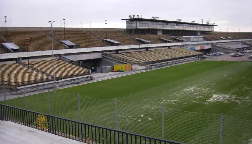 Pusta trybuna stadionu, największy stadion w Czechach, z zieloną murawą i ogrodzeniem.