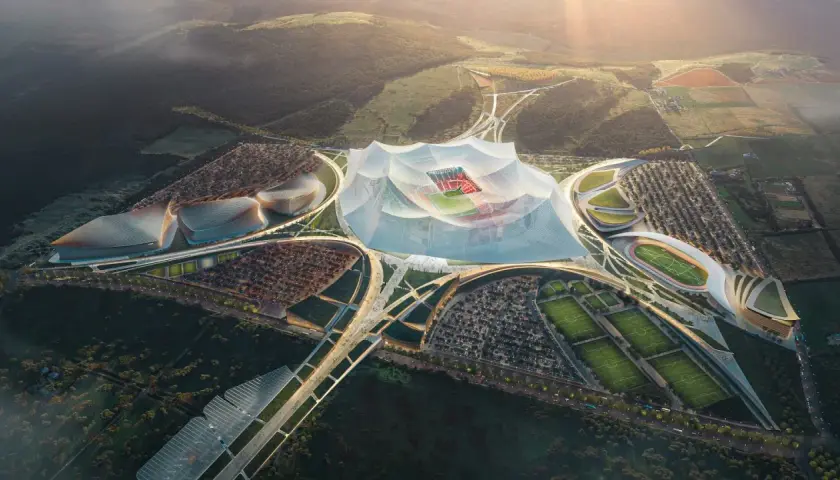 Futurystyczny kompleks sportowy z centralnym, zadaszonym stadionem, otoczony boiskami treningowymi i parkingami. Wygląda jak najwyżej położony stadion na świecie.