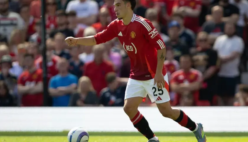 Manuel Ugarte w czerwonej koszulce Manchesteru United z numerem 25, biegnie po boisku, skupiony na grze.