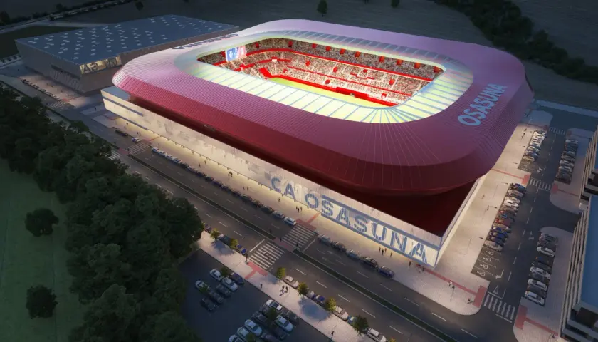 Nowoczesny stadion **El Sadar** w nocy, z czerwonym dachem i trybunami wypełnionymi kibicami. Obok budynek treningowy i parkingi.