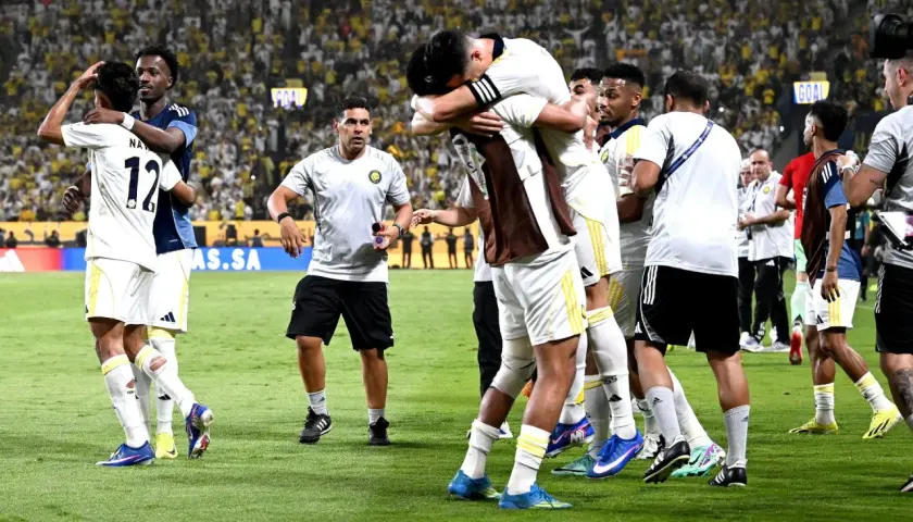 Piłkarze świętują zwycięstwo, przytulając się na boisku. W tle tłum kibiców, którzy przyszli zobaczyć, kiedy gra Ronaldo.