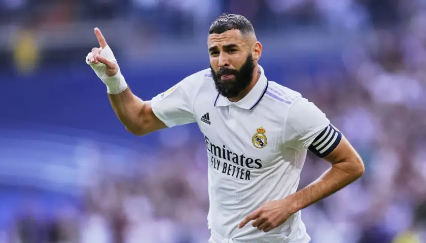 Piłkarz z numerem 8, Karim Benzema, świętuje bramkę. Ma zabandażowaną dłoń i opaskę kapitana na ramieniu.