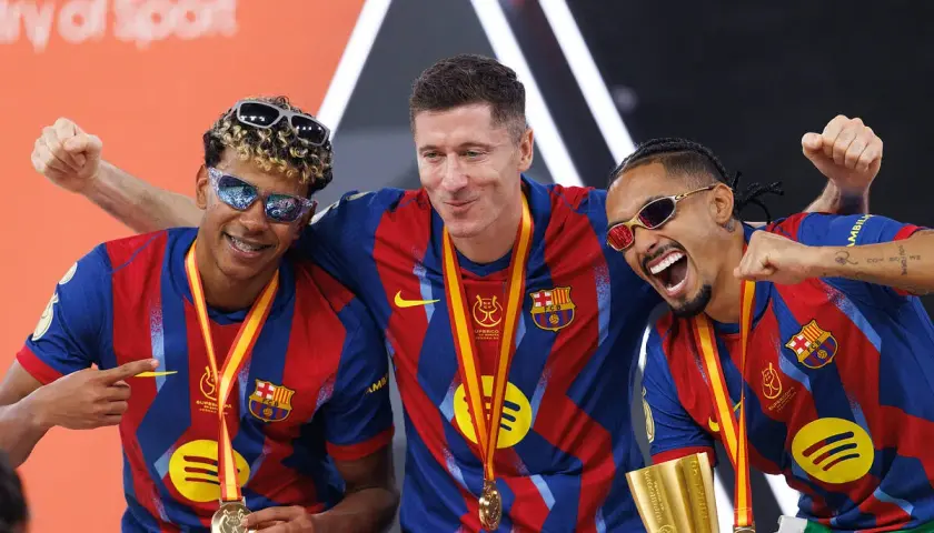 Trzej zawodnicy FC Barcelony w okularach przeciwsłonecznych świętują zdobycie Superpucharu Hiszpanii.