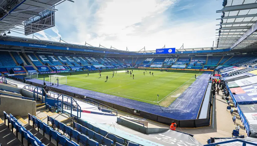 Piłkarze trenują na murawie King Power Stadium. Puste trybuny w niebieskich barwach czekają na kibiców.