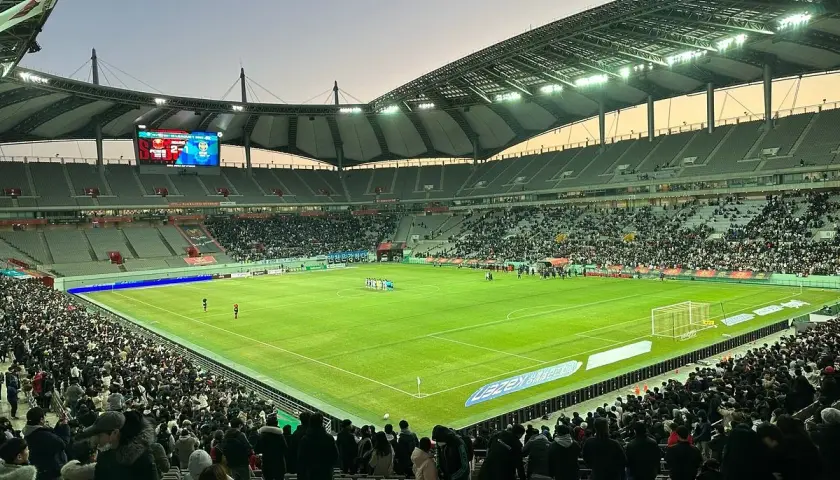 Widok na wypełniony po brzegi seulski stadion piłkarski, gdzie kibice czekają na rozpoczęcie meczu.