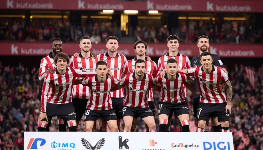 Athletic Bilbao – zawodnicy w czerwono-białych pasach stoją razem przed kibicami.