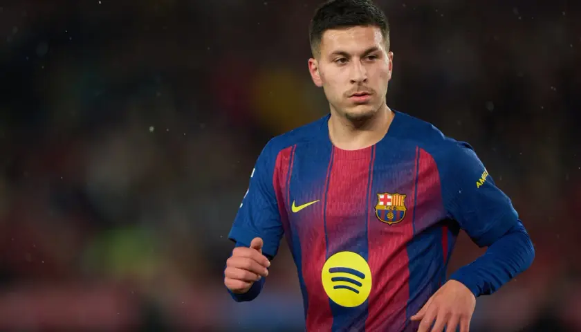 Młody piłkarz Roony Bardghji w koszulce FC Barcelony, z dumą nosi herb klubu.