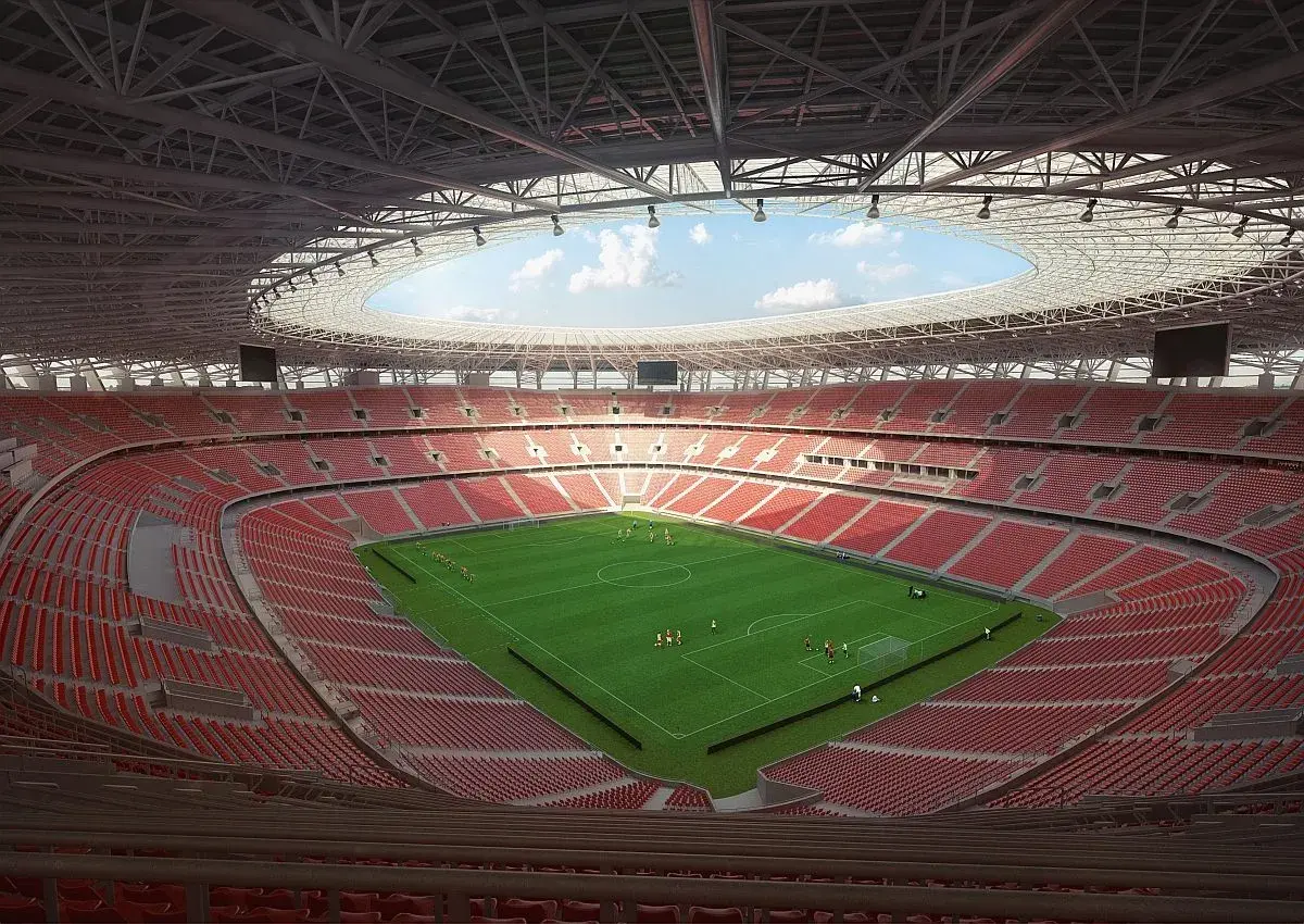 Nowy stadion w Budapeszcie z zieloną murawą i czerwonymi trybunami. Piłkarze trenują przed meczem.
