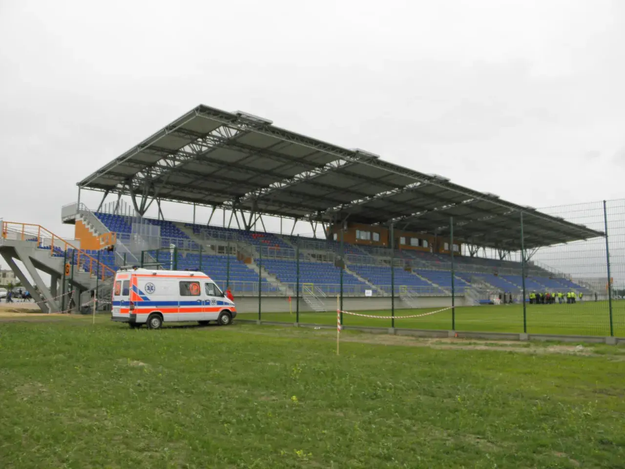Pogoń Siedlce stadion z ambulansem na murawie. Puste trybuny czekają na kibiców.