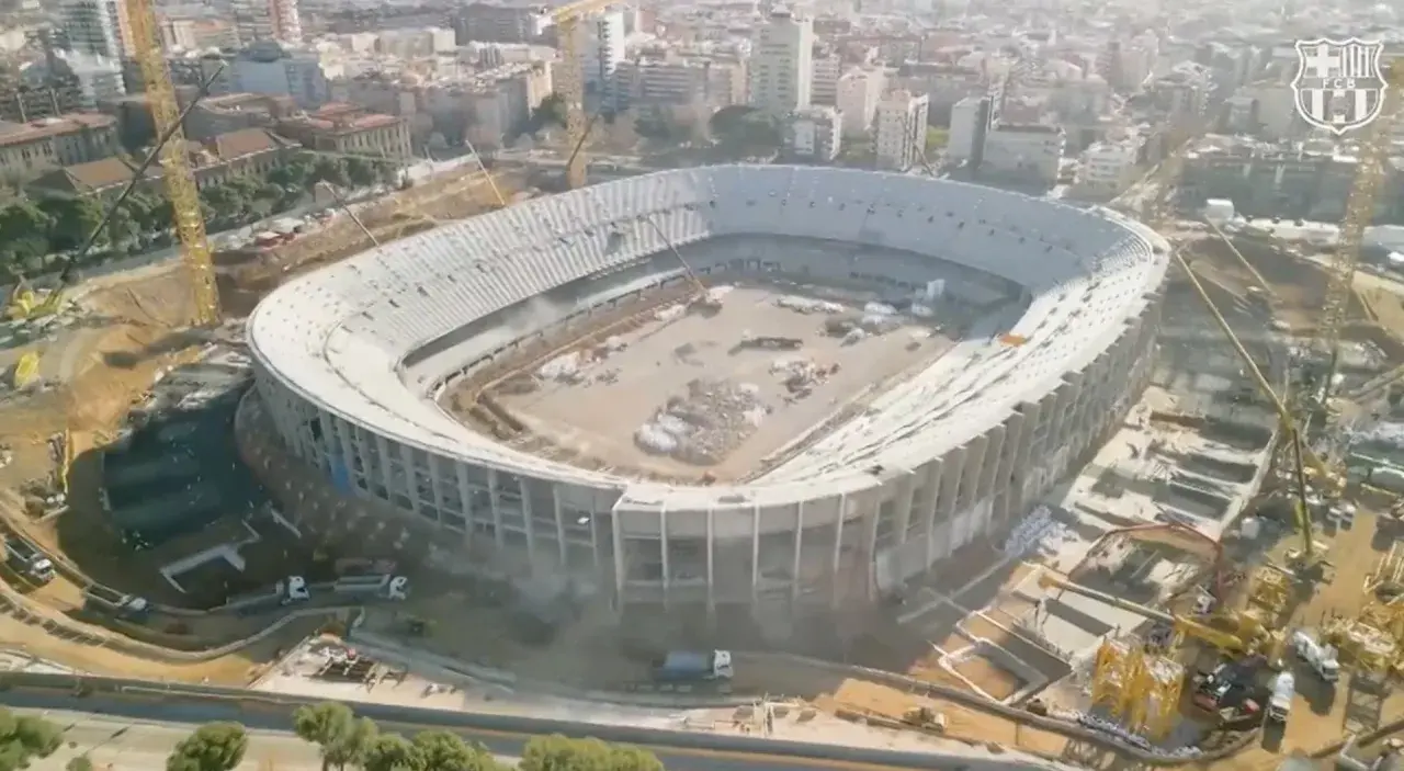 Widok z lotu ptaka na stadion barcelony nowy w budowie. Widać dźwigi i robotników pracujących nad konstrukcją.